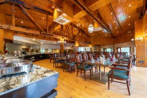 ein Esszimmer mit Tischen und Stühlen und Holzdecken in der Unterkunft Span Resort and Spa, Manali in Manali