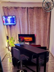 sala de estar con mesa, TV y ventana en Cambridge suites, en Cleethorpes