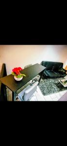 una mesa con una flor roja en un cuenco encima en Cambridge suites, en Cleethorpes