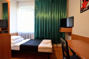 ein Schlafzimmer mit einem Bett mit einem grünen Vorhang in der Unterkunft Hotel Gracja in Kuźnia Raciborska