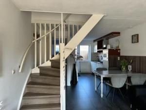 a kitchen and a living room with a staircase in a house at Hello Zeeland - Brouwersbuurt 31 in Domburg