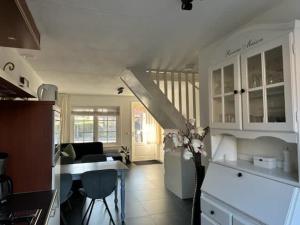 a kitchen with a table and a staircase in a room at Hello Zeeland - Brouwersbuurt 31 in Domburg