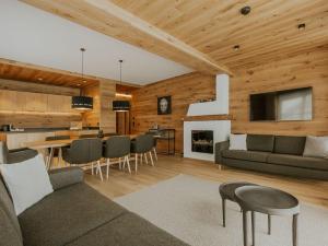 a living room with a couch and a table with chairs at Almrausch Lech Apartments in Lech am Arlberg