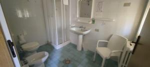 a white bathroom with a sink and a toilet at Country House UNA in Cupra Marittima