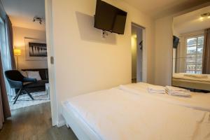 a bedroom with a bed with a television on the wall at Residenz am Balmer See - Kleine Auszeit - BS 21 mit Wellnessbereich in Balm +11 photos
