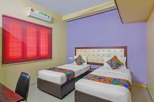 a bedroom with two beds and a window at Via Blue Moon Residency in Chennai