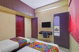 a hotel room with two beds and a desk at Via Blue Moon Residency in Chennai