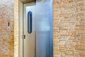 a metal door with a window in a brick wall at Via Blue Moon Residency in Chennai