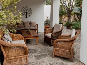 a patio with wicker chairs and a table at Karoo Cypress Guesthouse in Graaff-Reinet