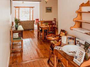 a living room with wooden floors and a dining room at Karoo Cypress Guesthouse in Graaff-Reinet