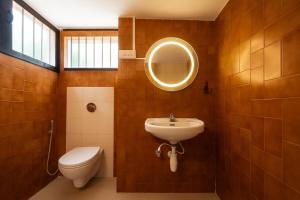 a bathroom with a sink and a toilet and a mirror at Casa Do Leão - Heritage Boutique Stay in Nerul +32 photos