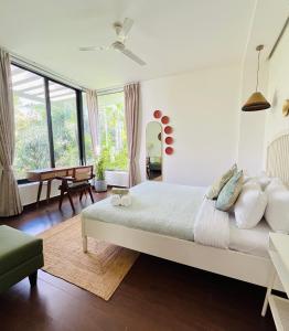 ein Schlafzimmer mit einem großen Bett und einem Tisch in der Unterkunft B Shore by evaddo Luxury 3BHK Villa with Private Pool & Jacuzzi in Anjuna