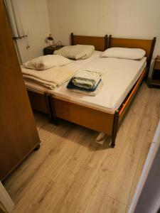 Schlafzimmer mit einem Bett mit weißer Bettwäsche und Holzböden in der Unterkunft Tonezza Home in Tonezza del Cimone