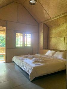 une chambre avec un grand lit dans une pièce dans l'établissement Lanta Thai Cottage, Bamboo House, à Ko Lanta Yai