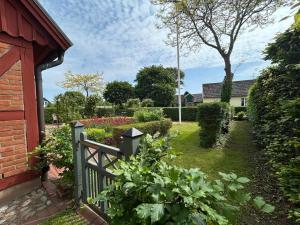 einen Garten mit einem Holzzaun und Blumen in der Unterkunft Traditional House In Old Viken in Viken