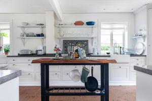 eine Küche mit weißen Schränken und einem Holztisch in der Unterkunft Traditional House In Old Viken in Viken