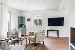 ein Wohnzimmer mit Sofa und Fernseher in der Unterkunft Traditional House In Old Viken in Viken