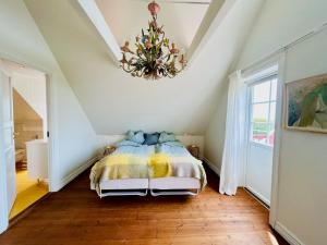 ein Schlafzimmer mit einem Bett und einem Kronleuchter in der Unterkunft Traditional House In Old Viken in Viken