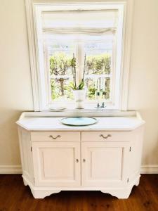 ein weißer Badezimmerwaschtisch mit Fenster und Waschbecken in der Unterkunft Traditional House In Old Viken in Viken + 18 Fotos