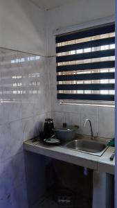 une cuisine avec un évier et une fenêtre dans l'établissement Guest Apartments, à New Weija