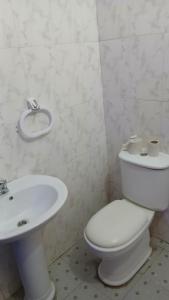 une salle de bain avec des toilettes blanches et un lavabo dans l'établissement Guest Apartments, à New Weija