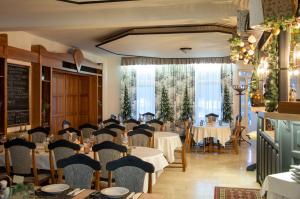 ein Restaurant mit Tischen und Stühlen in einem Raum in der Unterkunft Hotel Rittinger in Bonyhád