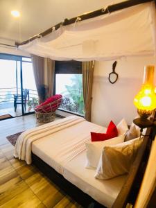 a bedroom with a large bed with red pillows at Mount shadows in Ella
