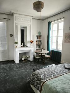 Schlafzimmer mit einem Bett, einem Tisch und einem Kamin in der Unterkunft La Boissière - Chambre d'hôtes premium in Sainte-Bazeille + 34 Fotos