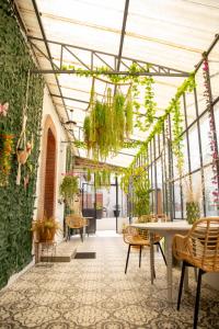ein Gewächshaus mit Pflanzen sowie einem Tisch und Stühlen in der Unterkunft La Boissière - Chambre d'hôtes premium in Sainte-Bazeille