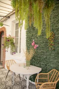 ein Tisch und zwei Stühle neben einer Wand mit Schmetterlingen in der Unterkunft La Boissière - Chambre d'hôtes premium in Sainte-Bazeille