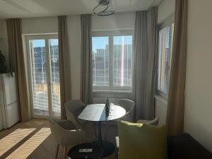 a living room with a table and chairs and windows at Lumio in Košice