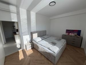 a white bedroom with a bed and a mirror at Lumio in Košice