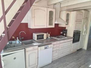 a kitchen with white cabinets and a microwave at l'oasis in La Farlède