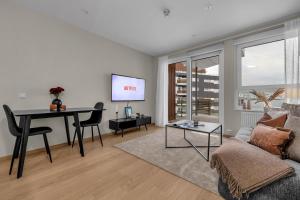 ein Wohnzimmer mit einer Couch, einem Tisch und einem Fernseher in der Unterkunft Northstay - Cozy Arctic Apartment, Free Parking in Tromsø
