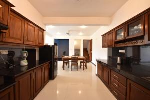 a kitchen with wooden cabinets and a dining room at Villa Serein - Garden Suite in Galle +16 photos