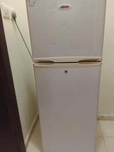 a white refrigerator freezer sitting in a kitchen at Alnan room's in Makkah
