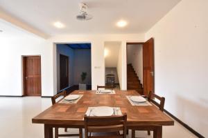 a dining room with a wooden table and chairs at Villa Serein - Garden Suite in Galle