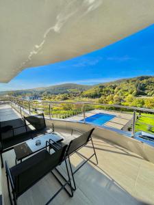 ヴルドニークにあるGreen panorama Vrdnikのテーブルと椅子付きの家のバルコニーから景色を望めます。