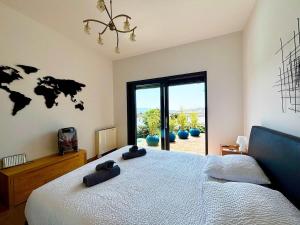 une chambre avec un grand lit et une grande fenêtre dans l'établissement Casamea - Villa Familiale, Piscine chauffée, Clim, à Ajaccio 34 autres photos