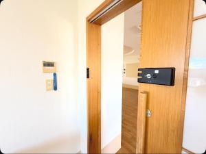 eine offene Tür in einem Zimmer mit einer Tür in der Unterkunft ハイ沖縄金武店トイレお風呂共用 プレオープン中駐車場有 ペット同伴可能長期滞在可能2025年10月より車貸し出しサービス有希望であればお申し付けください in Kin