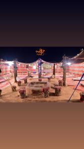 een paviljoen met een tafel en een tent 's nachts bij Terregite Taghit in Taghit +5 foto's