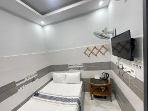 a small room with two beds and a tv at Ong 5 Homestay Can Tho in Can Tho +42 photos