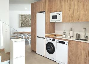 a kitchen with a washing machine and a microwave at Ría Vale 2 in Santa Marta de Magasca