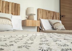 a bedroom with two beds with pillows and a lamp at Ría Vale 2 in Santa Marta de Magasca
