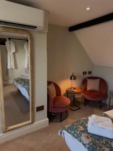 a bedroom with a mirror and a bed and a chair at Rylands Farm Guest House in Wilmslow