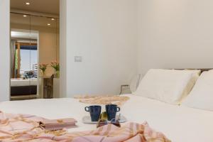 ein Schlafzimmer mit einem weißen Bett, auf dem Bücher und Brillen stehen in der Unterkunft Portopiccolo Apartments - Giardino vista castello in Portopiccolo Sistiana