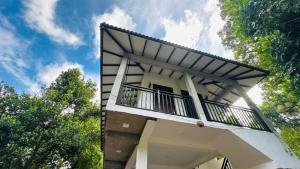 ein weißes Gebäude mit einem Balkon darauf in der Unterkunft Wannihami Home Stay in Sigiriya