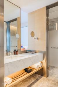 un bagno con un lavandino e un grande specchio di Xi'an Liban Hotel a Xi'an