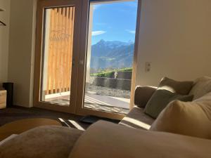 ein Wohnzimmer mit Sofa und Glasschiebetür in der Unterkunft Apartment Fidelia in Sankt Anton im Montafon