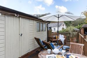 een patio met een tafel en een parasol bij Porth Chapel in Newlyn